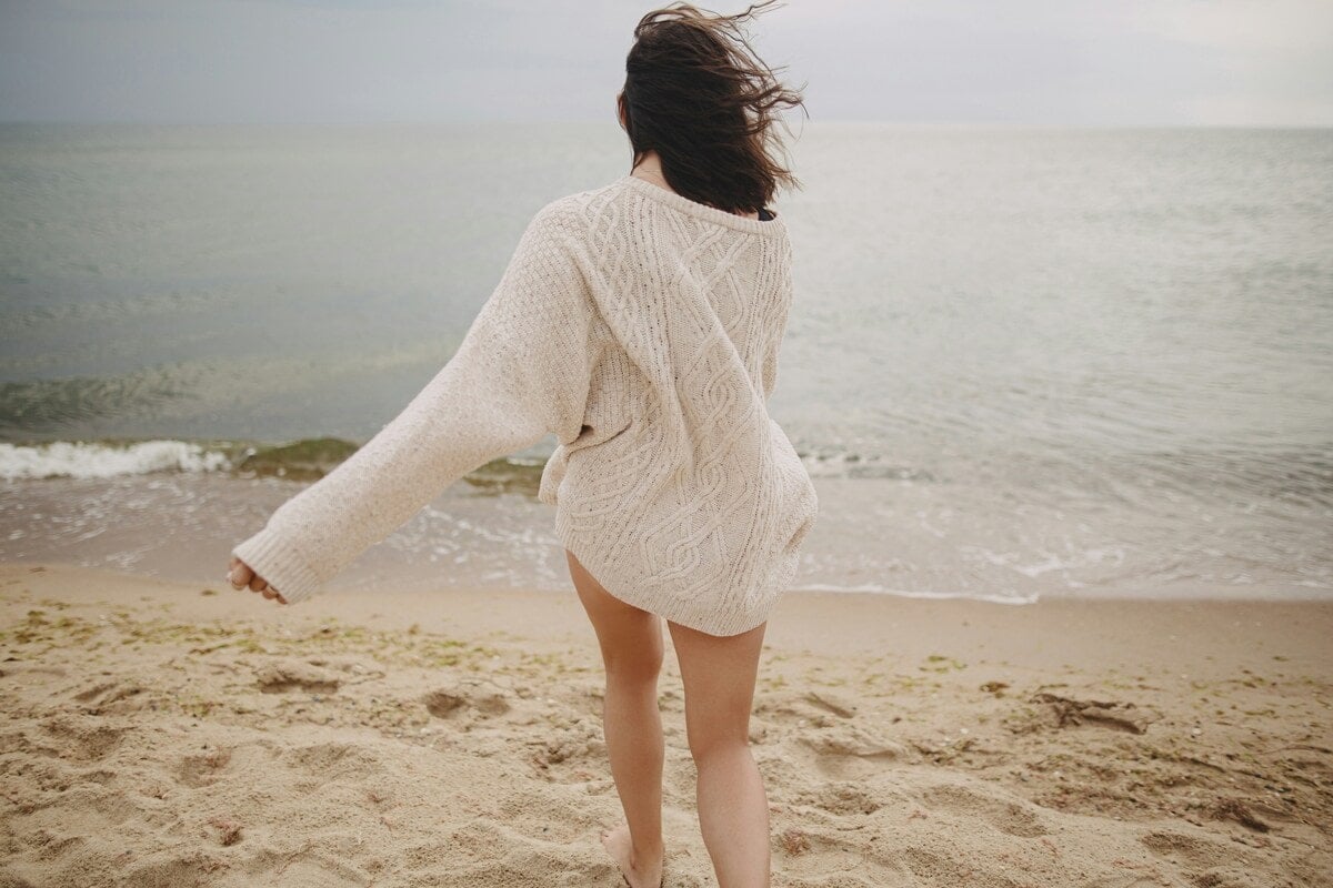 Vrouw die de voordelen van wandelmeditatie ervaart op het strand