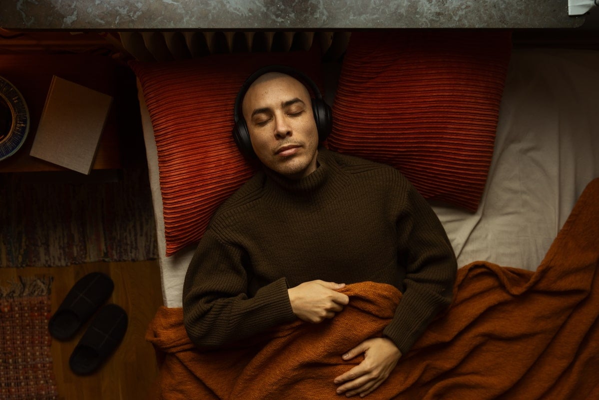 Man in bed die geniet van het beter slapen